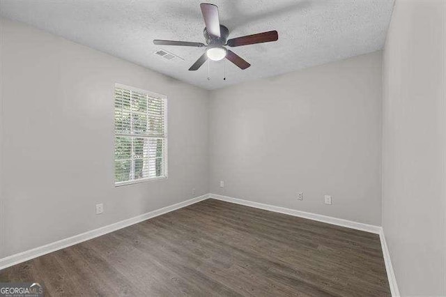 empty room with a textured ceiling, ceiling fan, and dark hardwood / wood-style floors