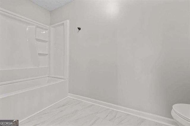 bathroom featuring shower / bath combination, a textured ceiling, and toilet