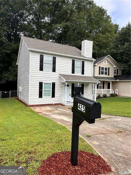 view of front of property featuring a front lawn and covered porch