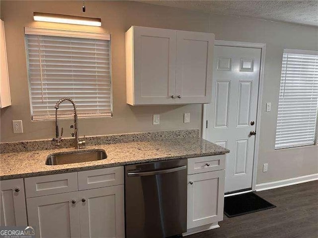 kitchen featuring light stone counters, a textured ceiling, sink, dishwasher, and white cabinetry