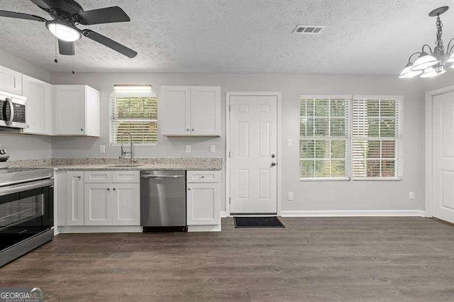 kitchen with pendant lighting, sink, white cabinets, and stainless steel appliances