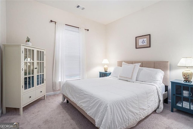 bedroom with multiple windows and light carpet