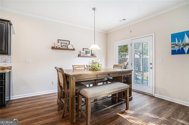 dining area featuring dark wood-type flooring and ornamental molding