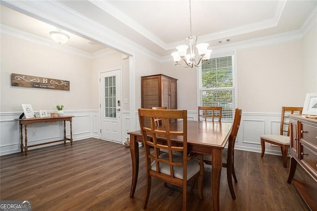 dining area with a chandelier, crown molding, and dark wood-type flooring