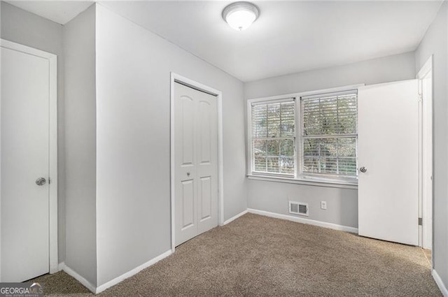 unfurnished bedroom with carpet and a closet