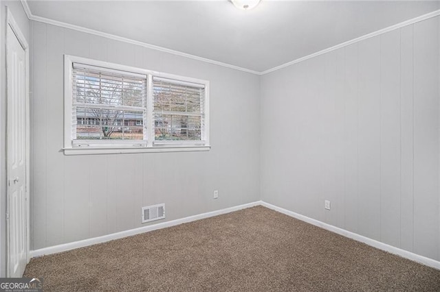 carpeted spare room featuring crown molding