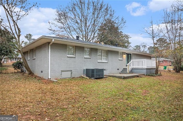 back of house featuring central air condition unit, a lawn, and a deck