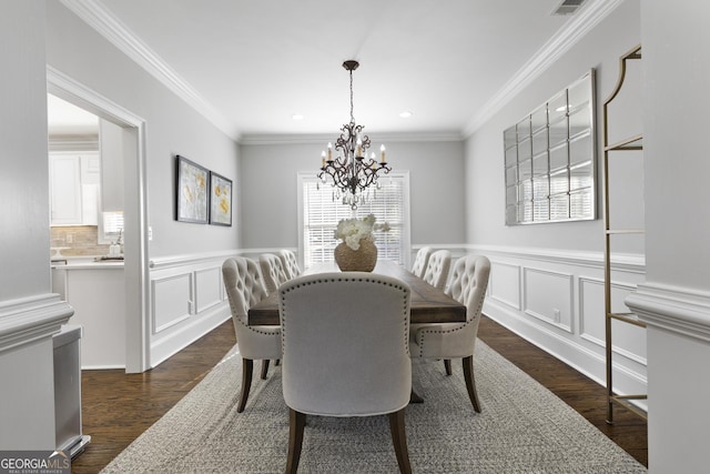 dining area featuring dark hardwood / wood-style floors, ornamental molding, and an inviting chandelier