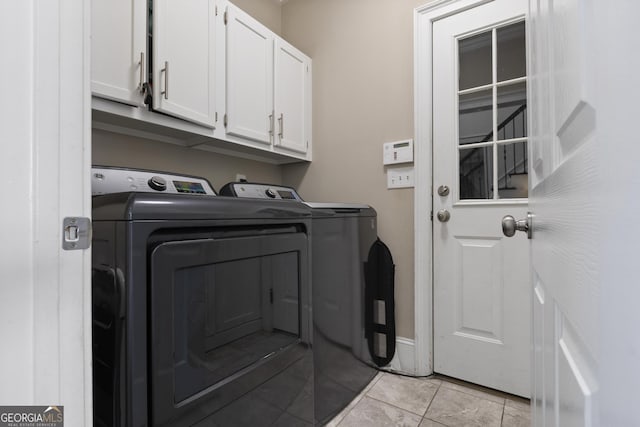 laundry room featuring cabinets, separate washer and dryer, and light tile patterned floors