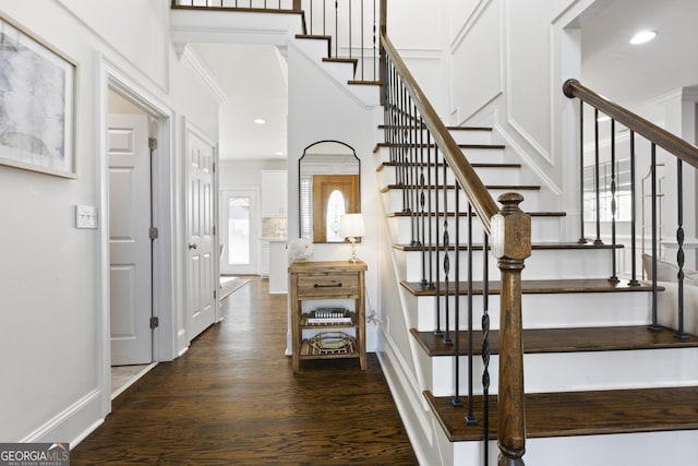 stairway featuring hardwood / wood-style floors and crown molding