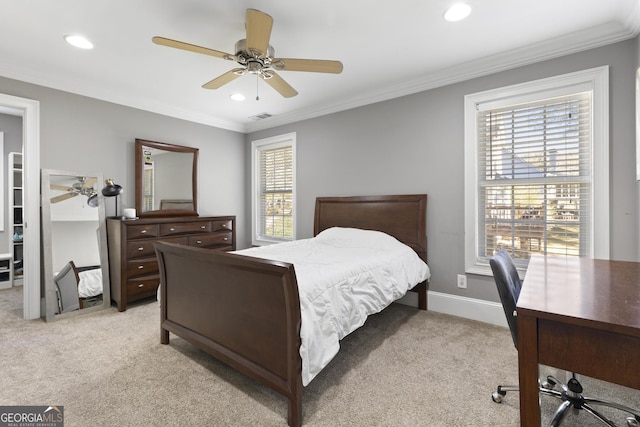 carpeted bedroom featuring ceiling fan and crown molding