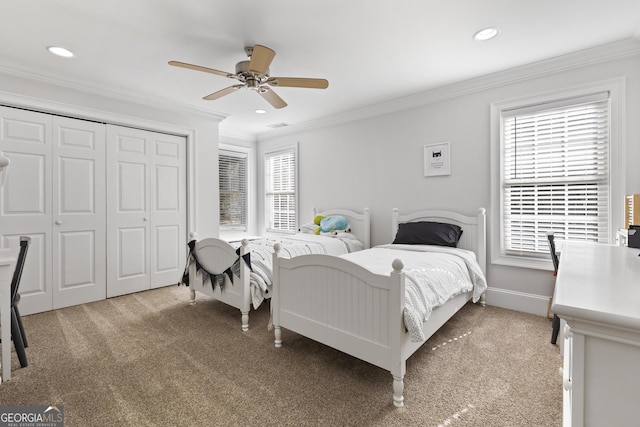 carpeted bedroom featuring a closet, ceiling fan, and ornamental molding