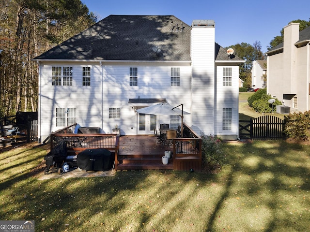 back of house with a lawn and a deck