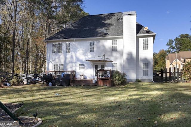 rear view of property with a deck and a lawn