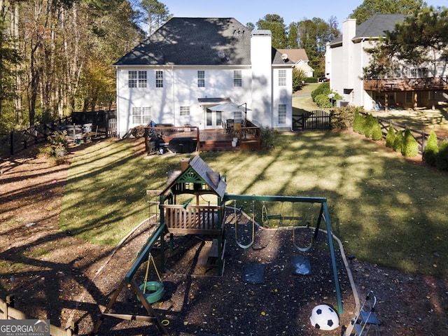 back of house with a lawn and a playground