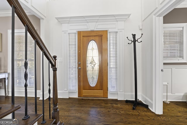 foyer entrance with dark wood-type flooring and ornamental molding