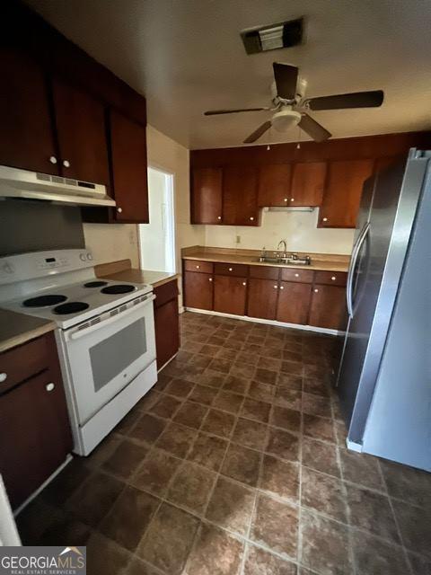 kitchen with white range with electric cooktop, ceiling fan, stainless steel refrigerator, and sink