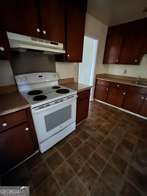 kitchen featuring dark brown cabinets, white electric stove, and sink