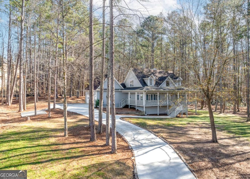 3820 Mink Livsey Rd, Snellville, GA 30039 - view of front of house with covered porch, driveway, stairway, a forest view, and a front lawn