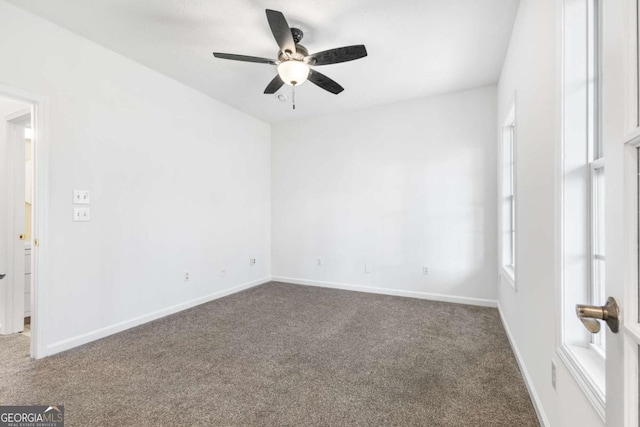 carpeted spare room featuring ceiling fan