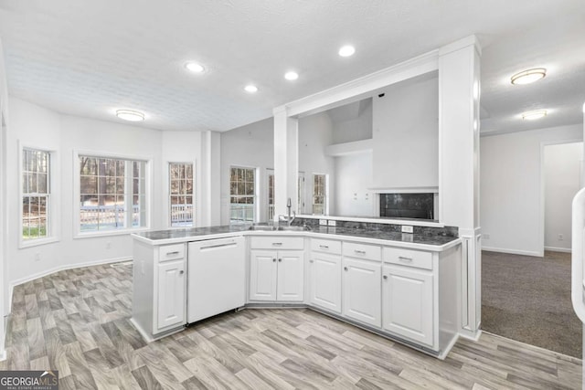 kitchen with white cabinetry, sink, kitchen peninsula, white dishwasher, and light hardwood / wood-style floors