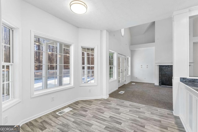 interior space with a textured ceiling and light hardwood / wood-style flooring