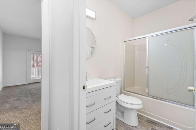 full bathroom featuring vanity, toilet, and bath / shower combo with glass door