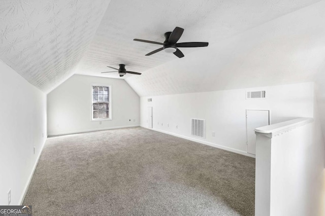 bonus room featuring a textured ceiling, ceiling fan, carpet floors, and vaulted ceiling