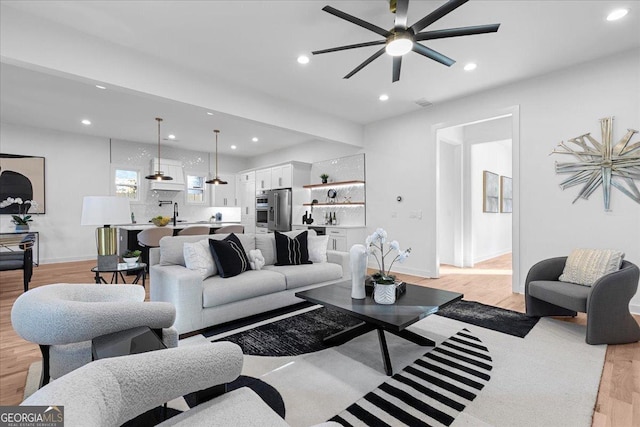 living room featuring light wood-type flooring and ceiling fan