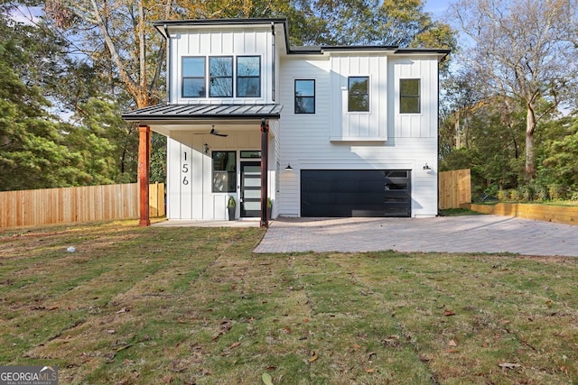 view of front of property with ceiling fan, a front yard, and a garage