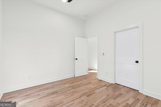 unfurnished bedroom with ceiling fan and light wood-type flooring