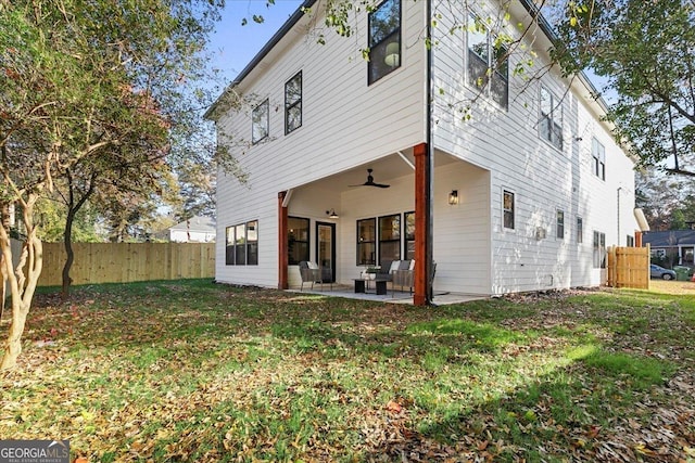 rear view of property with a lawn, ceiling fan, and a patio