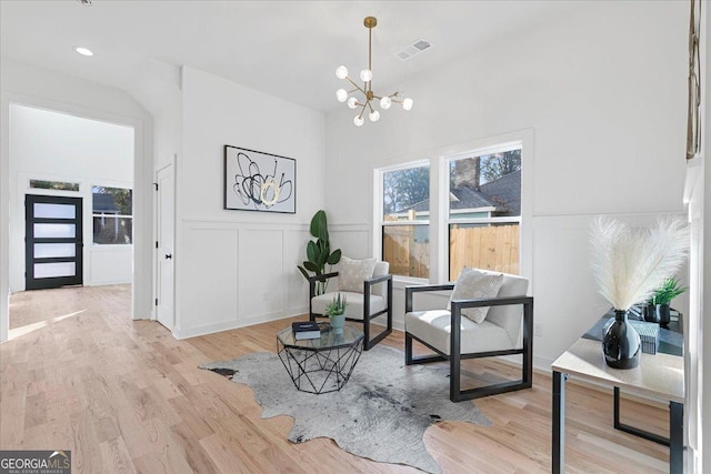 living area with a chandelier and light hardwood / wood-style flooring