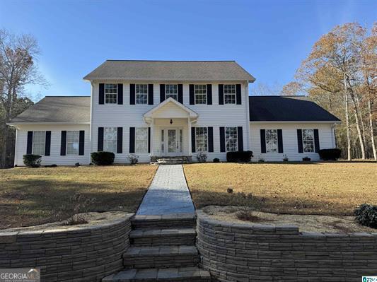 colonial-style house with a front lawn