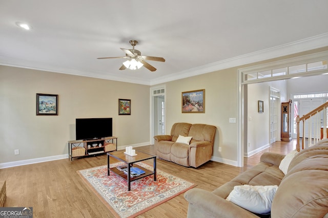 living room with crown molding, ceiling fan, and light wood-type flooring