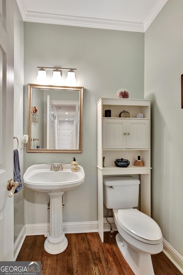 bathroom featuring wood-type flooring, ornamental molding, and toilet