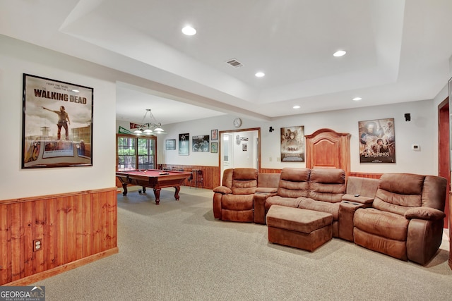 carpeted cinema room featuring pool table, wooden walls, and a raised ceiling