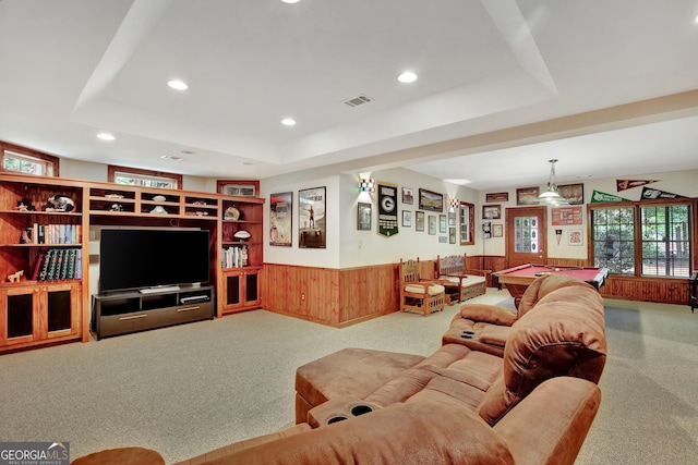 living room featuring wooden walls, a tray ceiling, and billiards