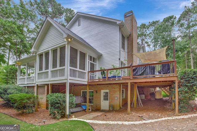 back of house featuring a wooden deck and a sunroom