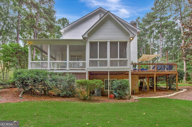 back of house featuring a wooden deck, a yard, a sunroom, and central air condition unit