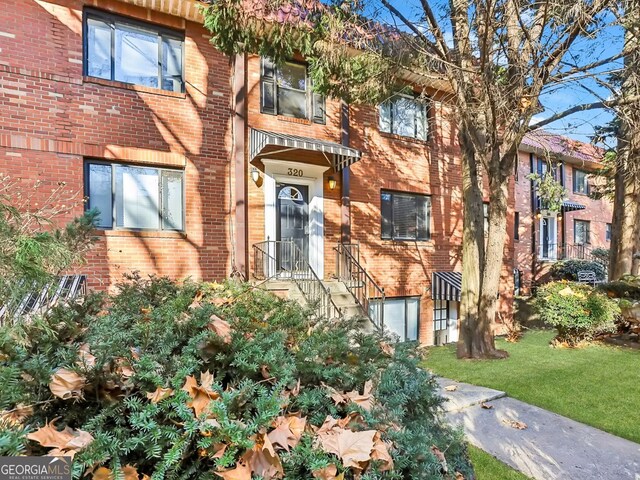 320 3rd St NE Unit 1, Atlanta, GA 30308 - view of property featuring an attached garage, a front yard, and brick siding