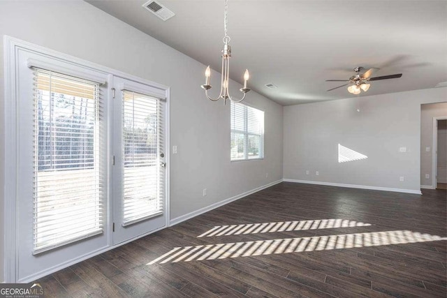 empty room with ceiling fan with notable chandelier and dark wood-type flooring