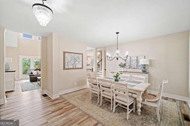 dining area featuring an inviting chandelier and light hardwood / wood-style floors