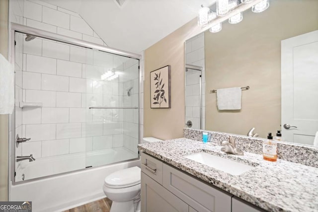 full bathroom featuring toilet, bath / shower combo with glass door, hardwood / wood-style flooring, and vanity