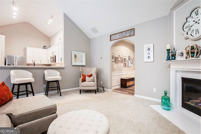 carpeted living room featuring vaulted ceiling