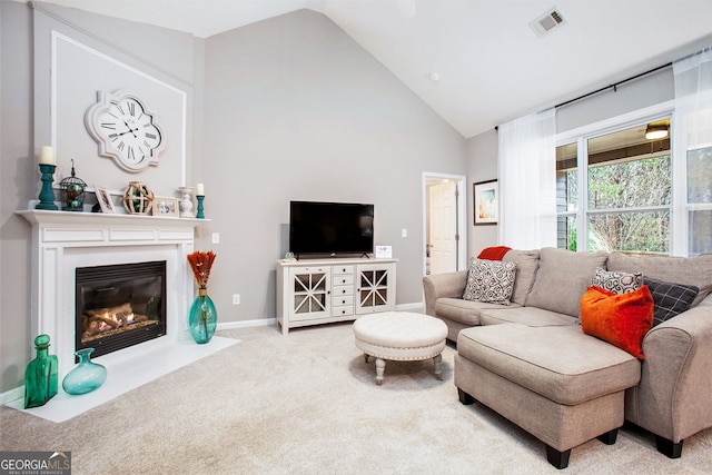 carpeted living room with high vaulted ceiling