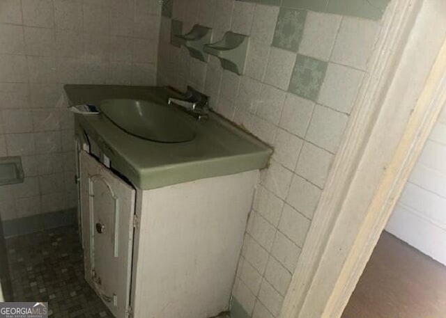 bathroom with vanity and tile walls