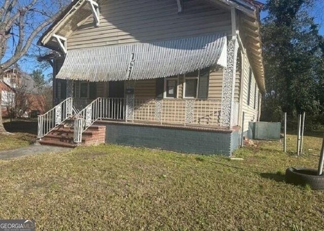 view of front of property with covered porch and a front yard