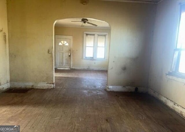 interior space with ceiling fan, crown molding, and dark wood-type flooring