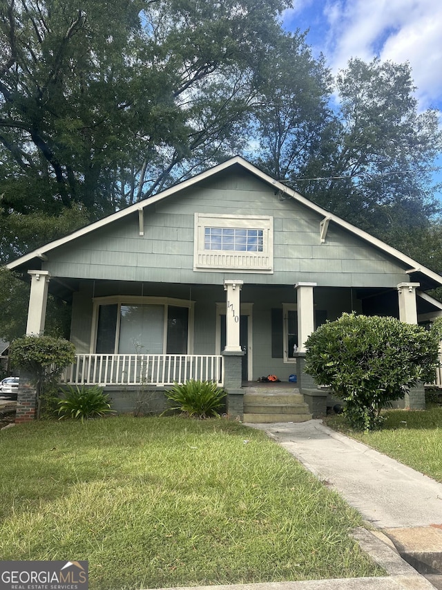 bungalow featuring a front yard and covered porch